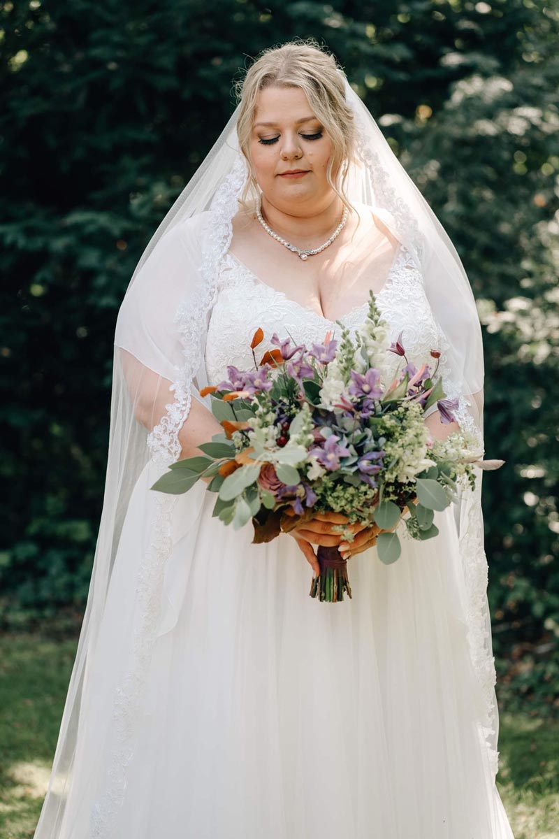 Curvy Braut in München mit schönem Brautstrauß